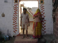 Ein Töpfer mit seiner Frau vor dem verzierten Eingang zu ihrem Haus